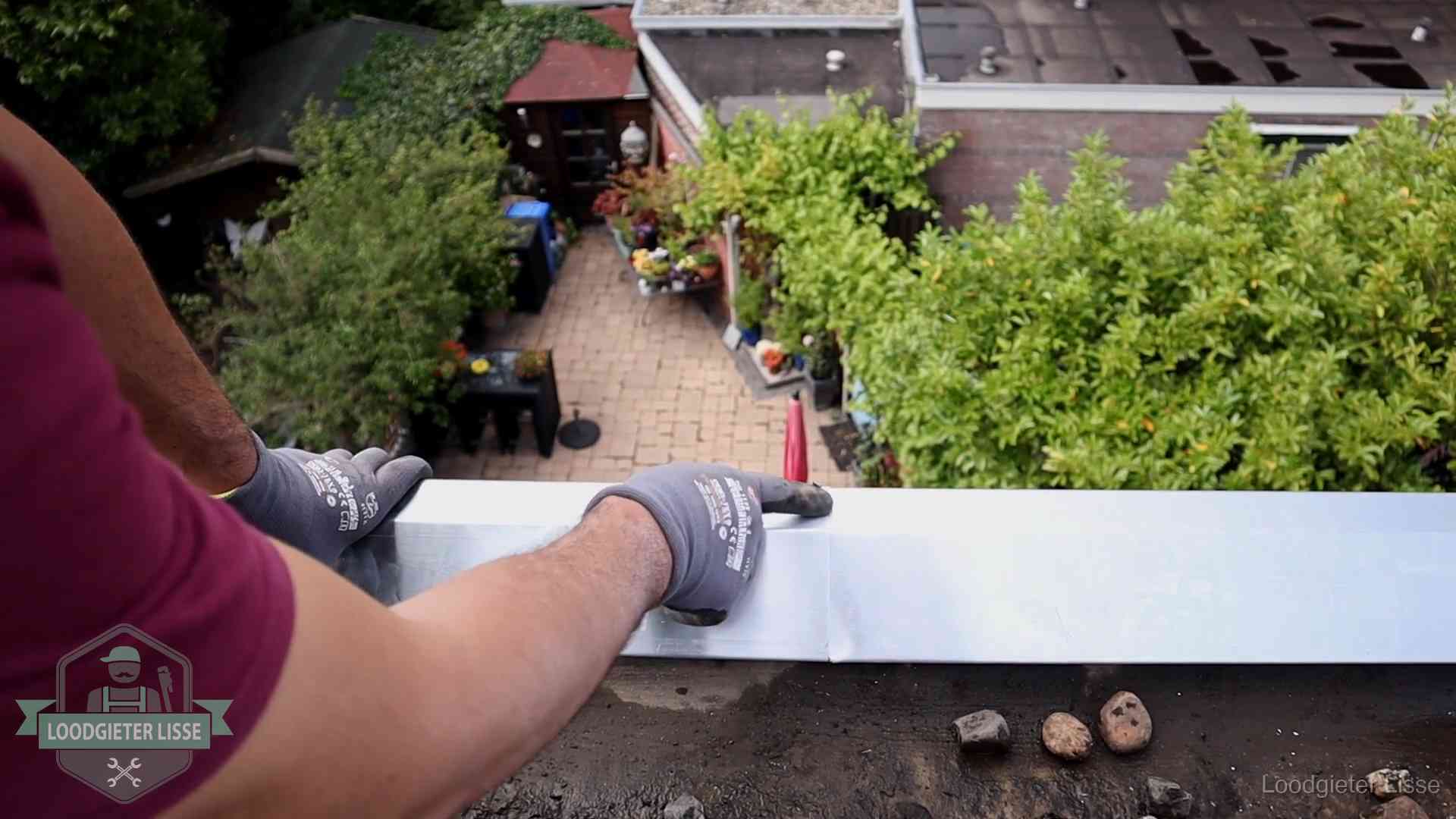 Daklekkage geregeld in Lisse Vakman plaatst een daktrim op de dakrand van een woning in Lisse