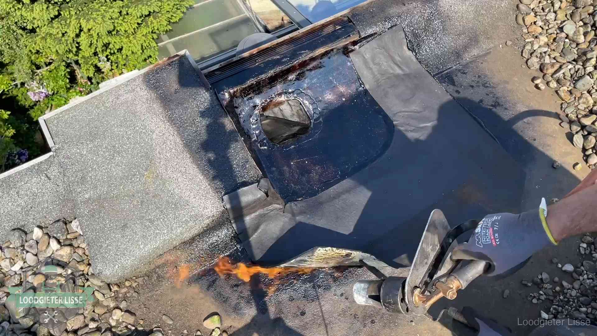 Daklekkage repareren in Lisse Dakdekker brandt bitumen rond een doorvoer tijdens een daklekkage-reparatie in Lisse