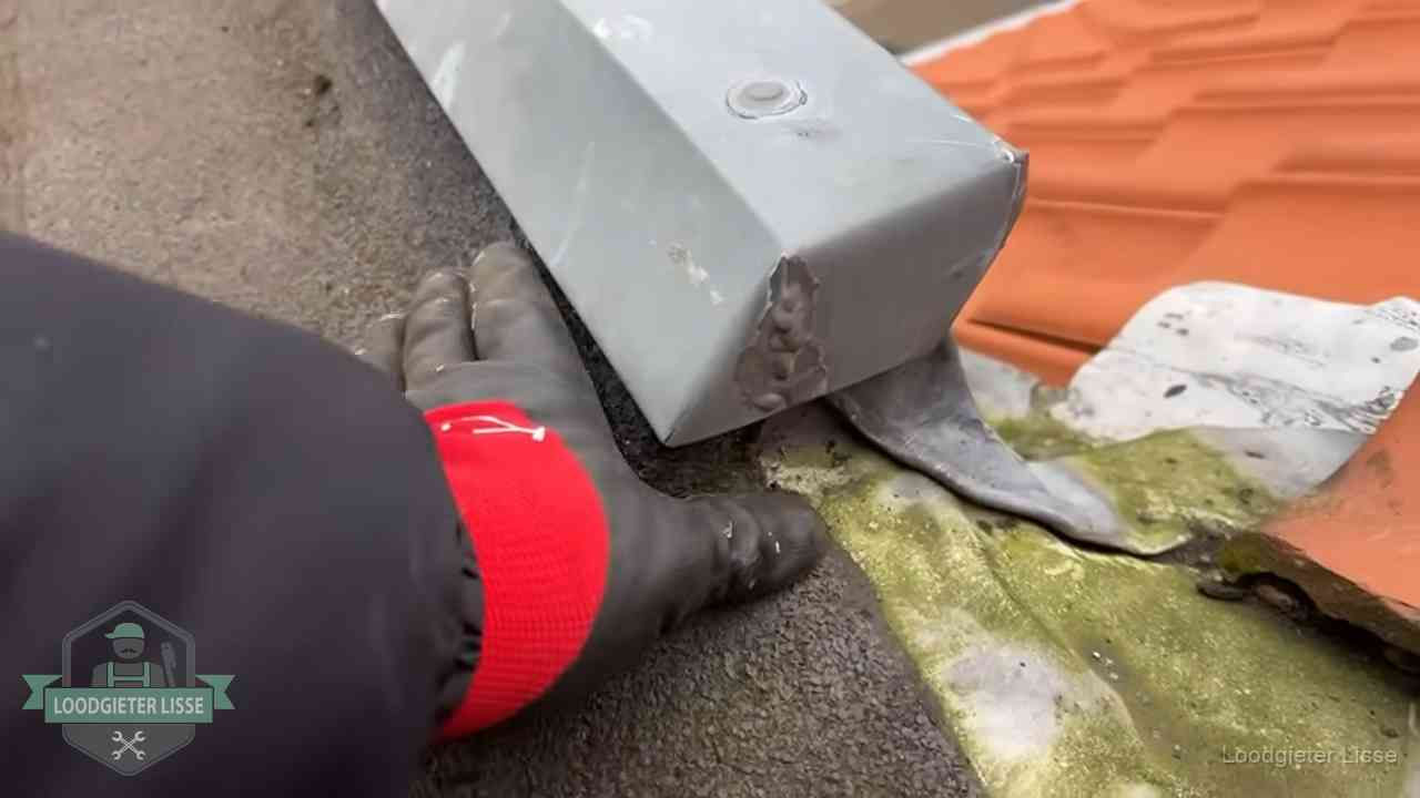 Hemelwaterafvoer en dakgoot controleren in Lisse Controle van een zinken hemelwaterafvoer met loodslab bij dakpannen in Lisse