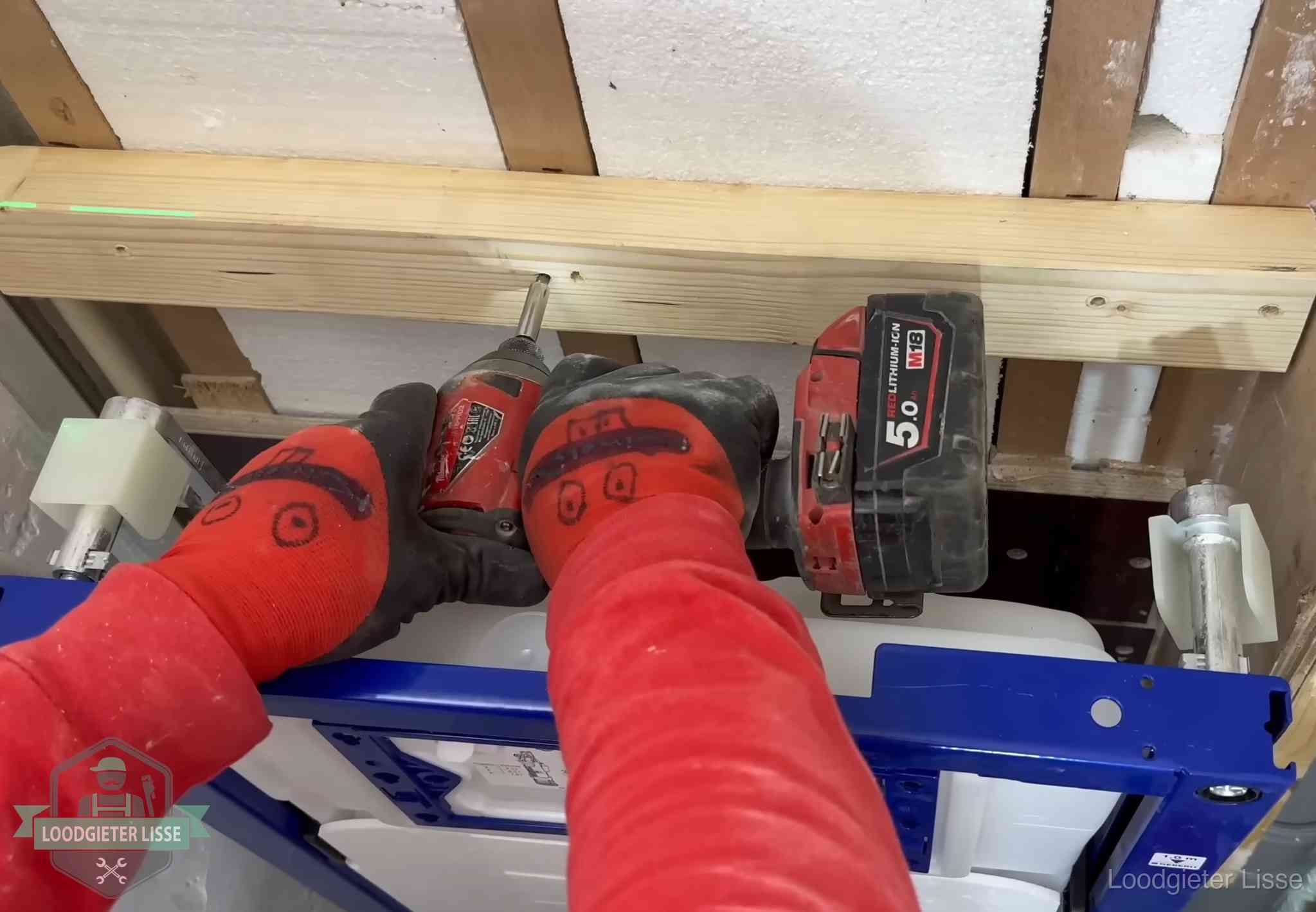 Monteur bevestigt een inbouwreservoir voor een hangend toilet in Lisse