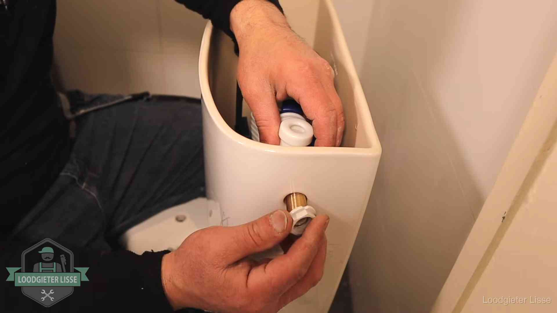 Loodgieter monteert de vlotterkraan van een stortbak bij een toilet in Lisse