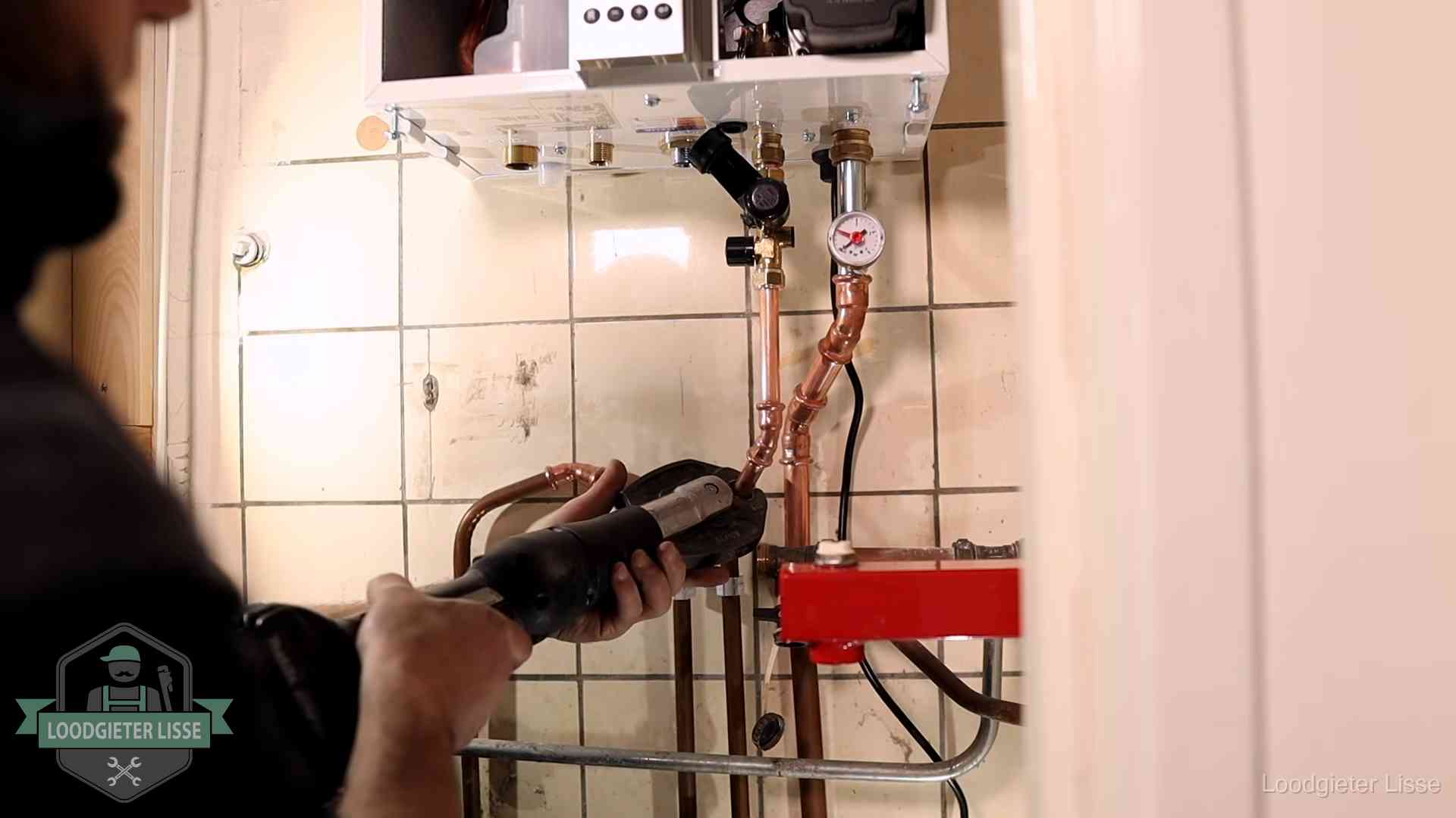 Cv-ketel onderhoud in Lisse Monteur werkt aan de leidingen onder een cv-ketel in Lisse