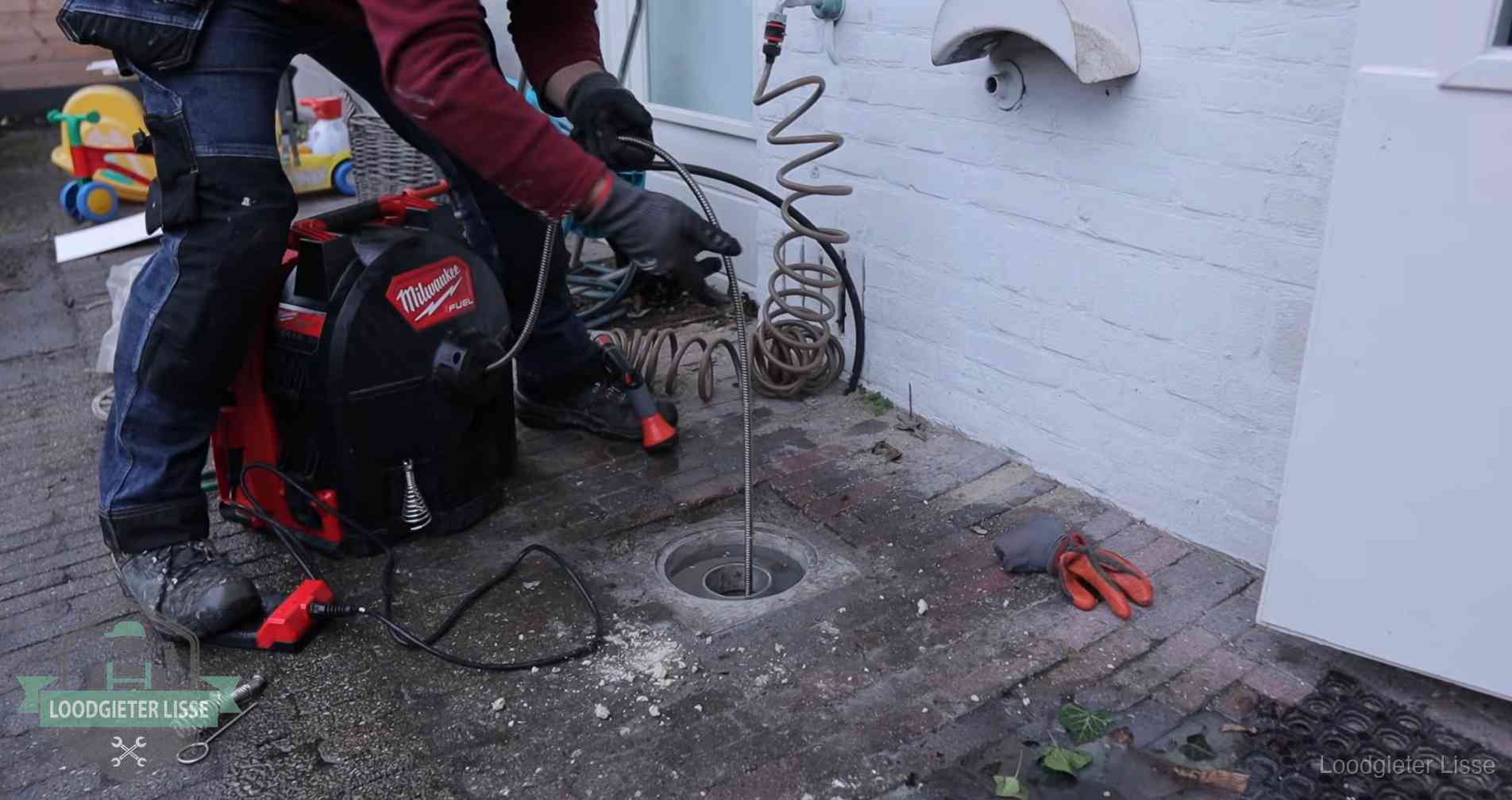 Erfgrens en gemeenteriool in Lisse Ontstoppingsputje in de bestrating naast de gevel van een woning in Lisse