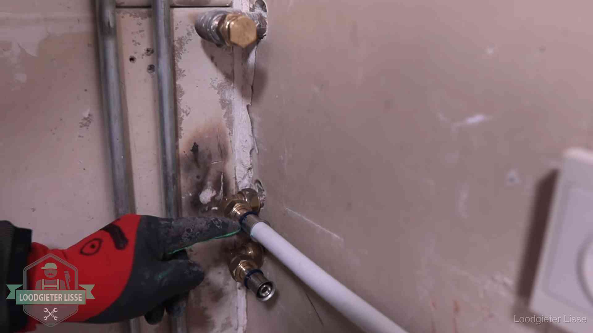 Garantie op loodgieterswerk in Lisse Loodgieter wijst de persfitting op nieuwe muuraansluitingen aan in een woning in Lisse
