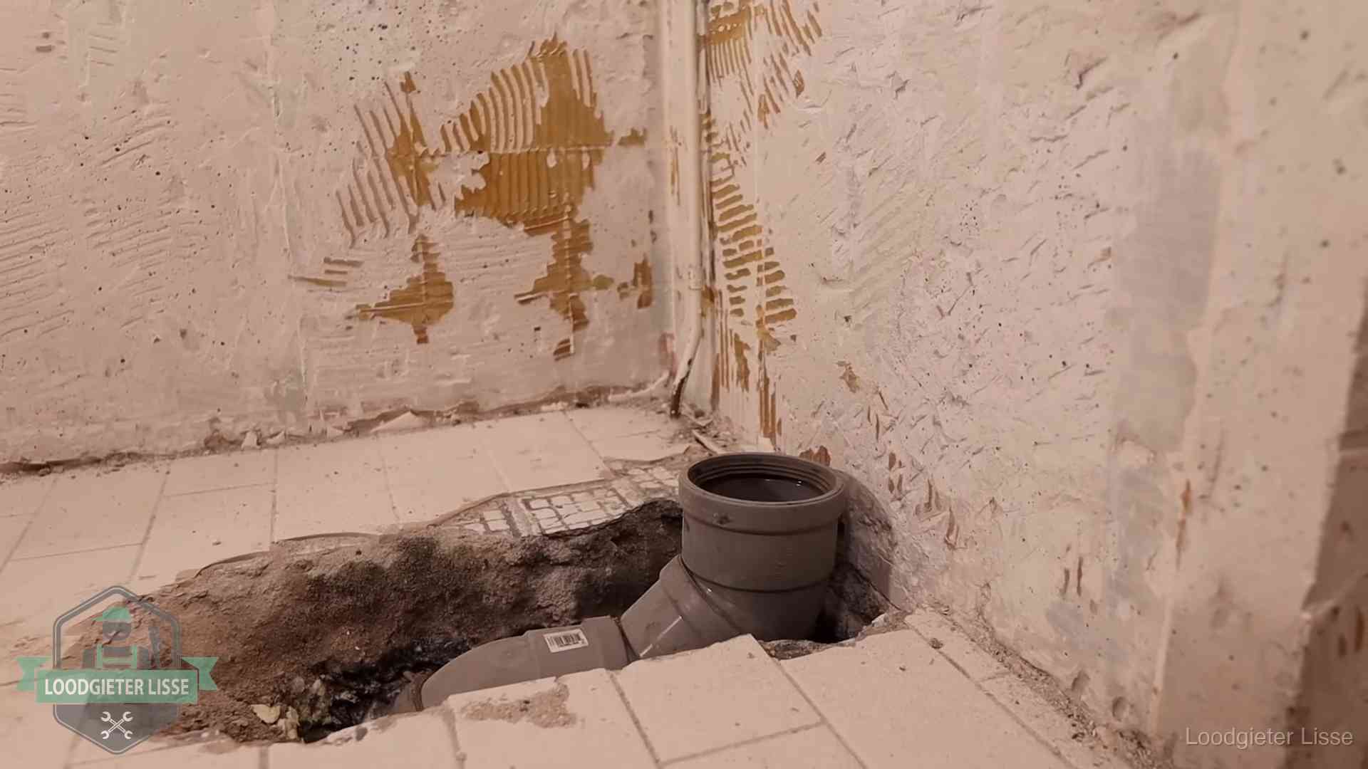 Verzakt riool herstellen in Lisse Opengebroken vloer met een nieuwe pvc-rioolbocht in een gegraven sleuf in Lisse