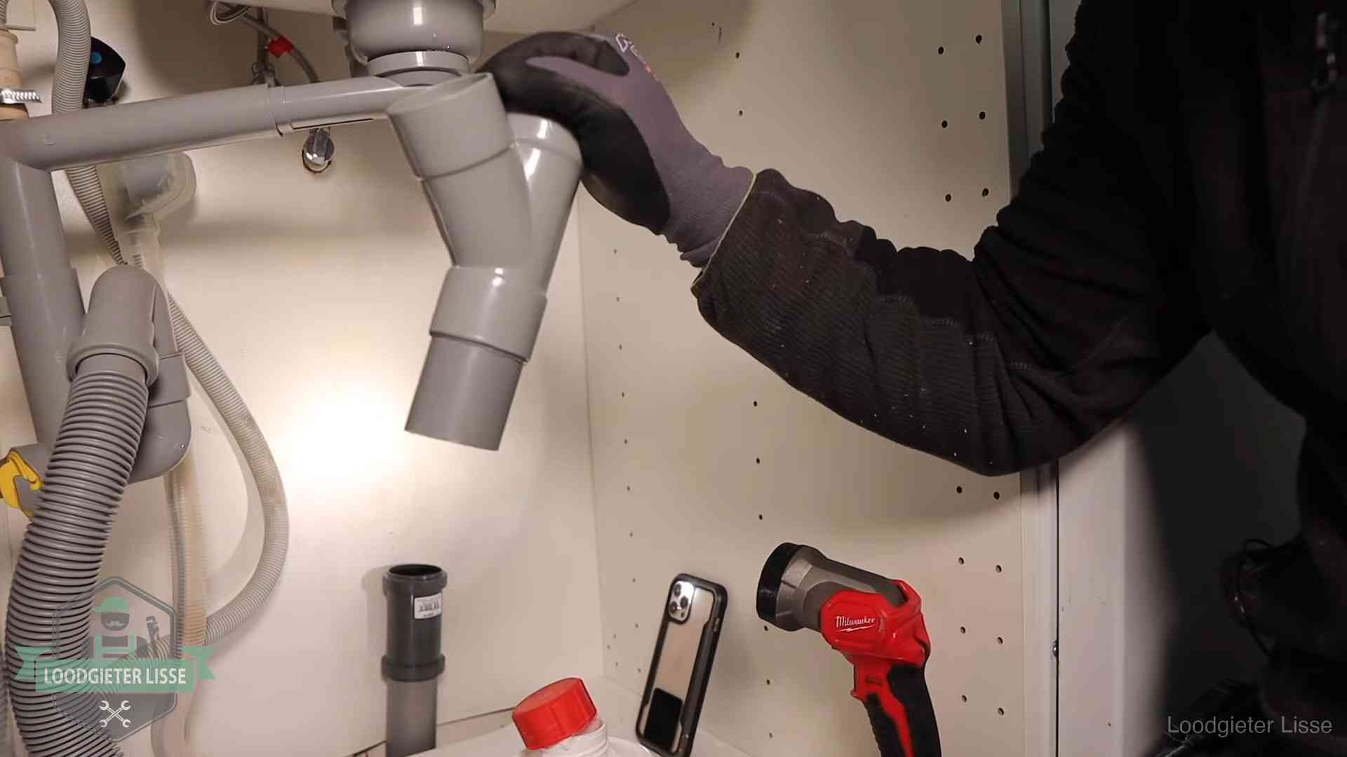 Rioollucht in huis verhelpen in Lisse Loodgieter demonteert het sifon- en afvoerwerk onder een gootsteen in Lisse bij stankklachten