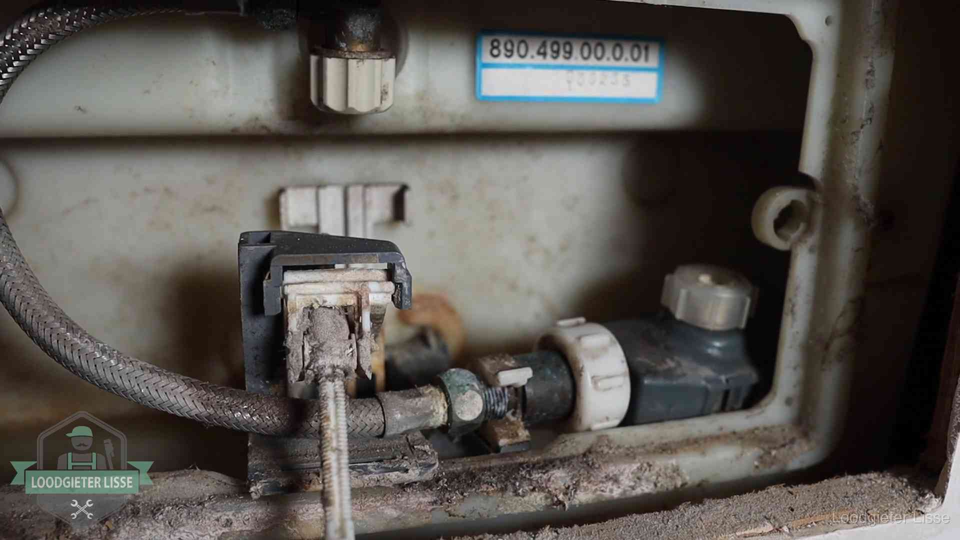 Verkalkt binnenwerk van een stortbak met vlotterkraan in Lisse