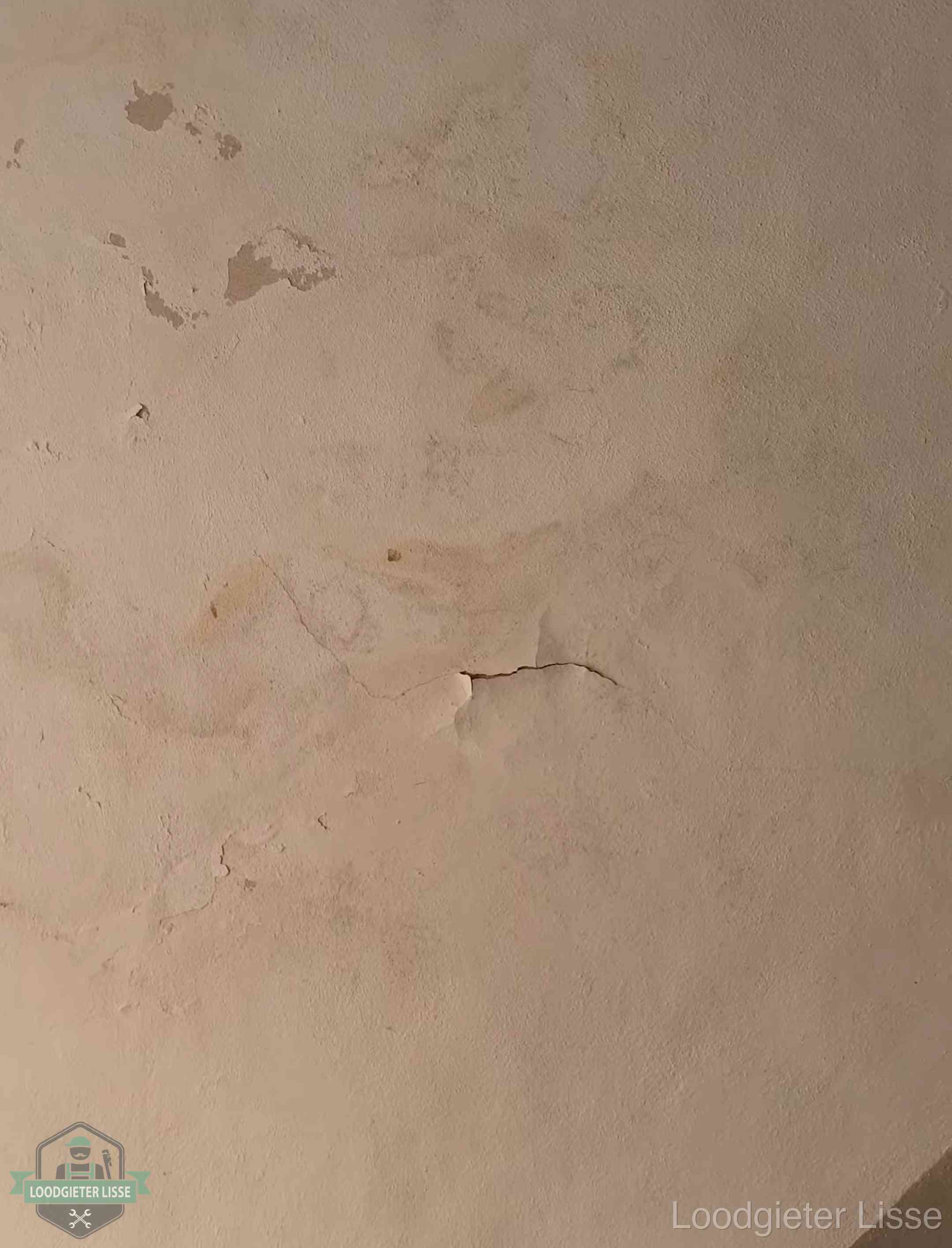 Vochtkringen en afbladderende verf op een plafond in Lisse, schade voor het meetrapport en de verzekering