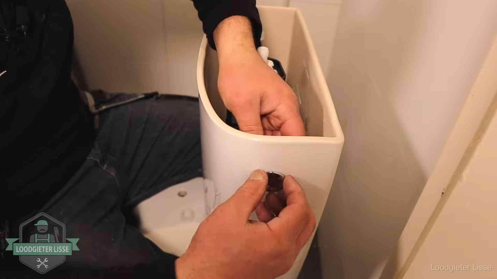 Drukknop van een duoblok-stortbak wordt gemonteerd bij een toilet in Lisse