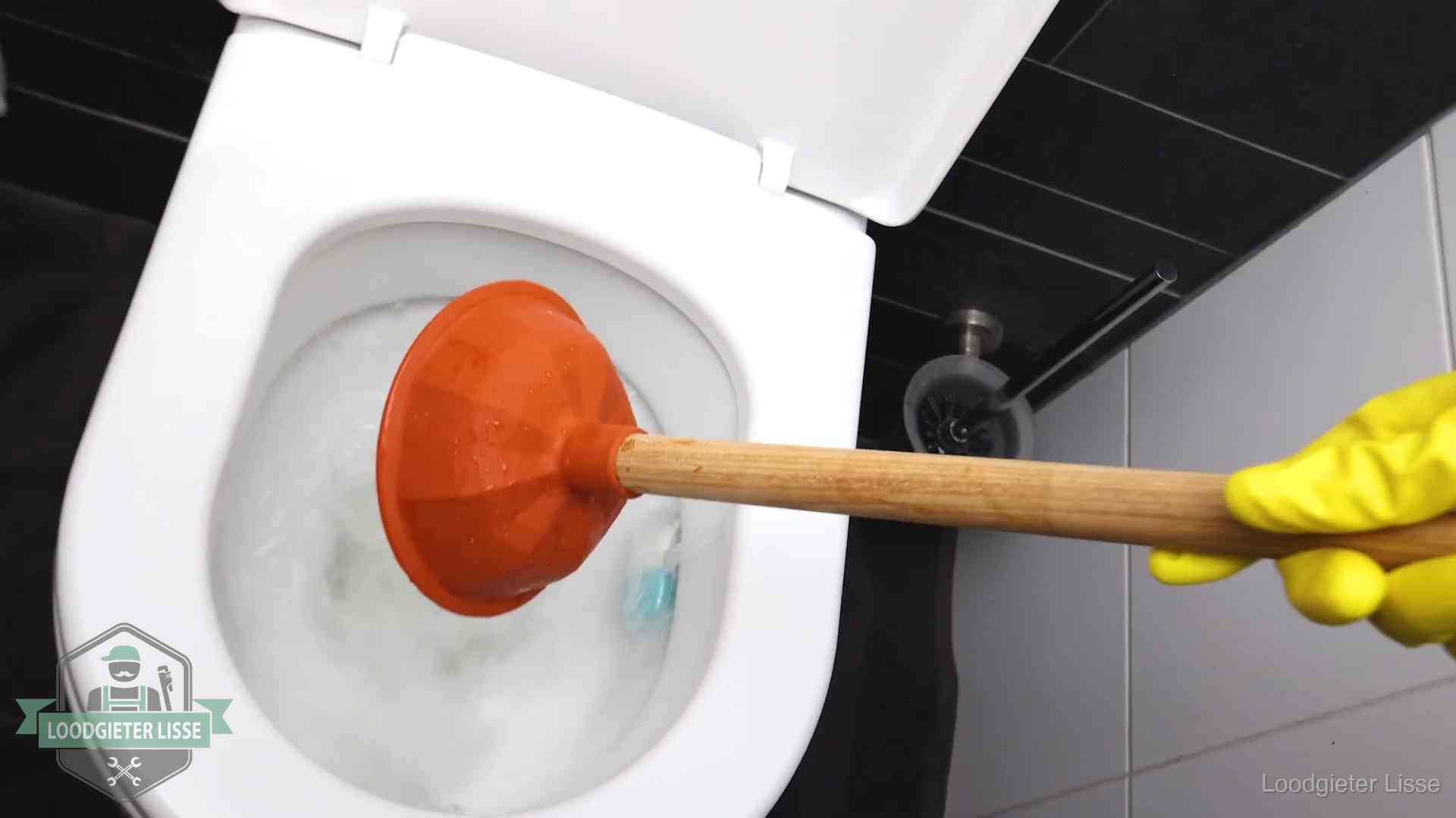 Plopper wordt in de wc-pot gedrukt bij het ontstoppen van een toilet in Lisse